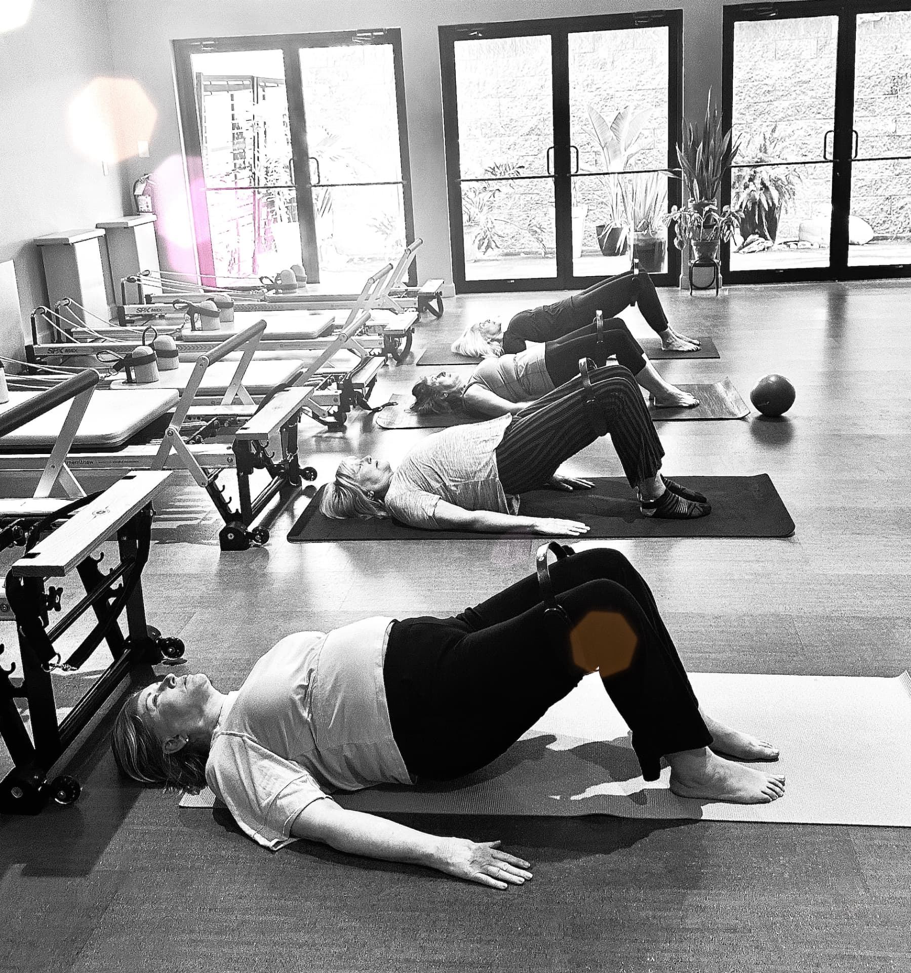 A small group of clients holding a bridge position on their mats during a class at Selah