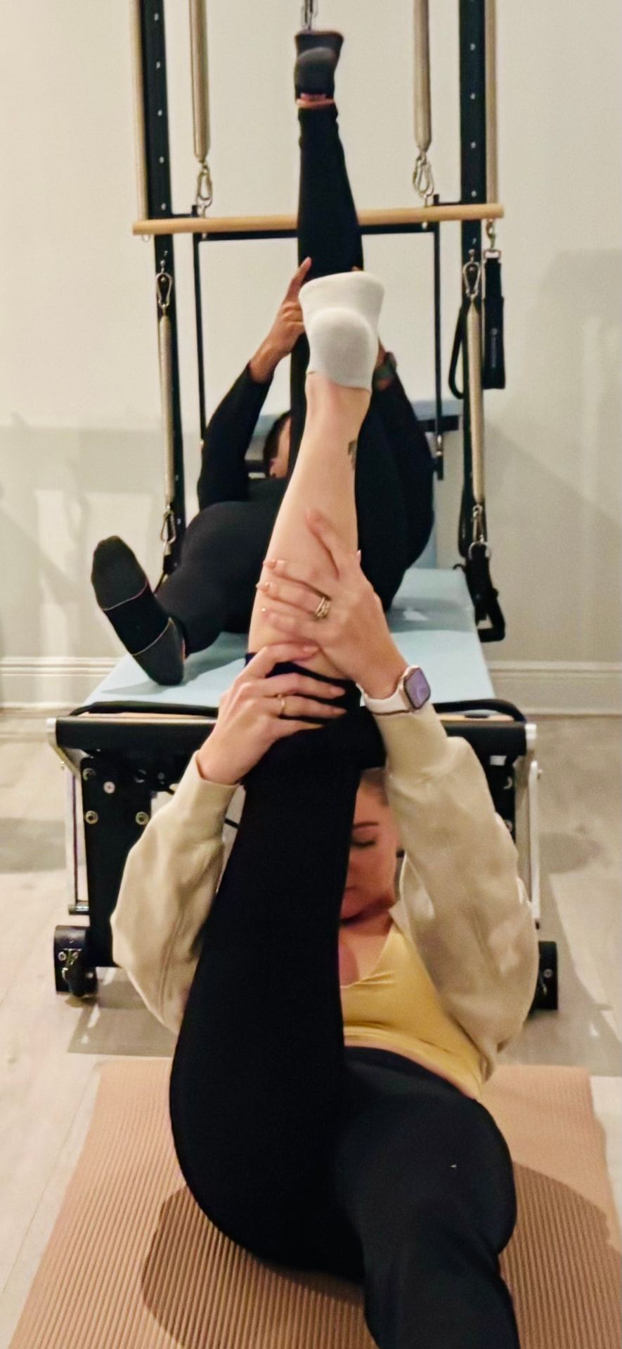 Footbar placement during a class at Selah Pilates, Ocean Springs A client's hands and feet placed precisely on the reformer footbar during an exercise