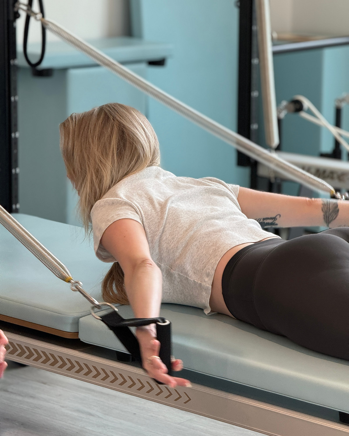 Client working on the reformer with instructor guidance